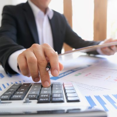 asian business meeting with hand pointing graph discussion and analysis data charts and graphs and using a calculator to calculate  numbers.Business finances and accounting concept